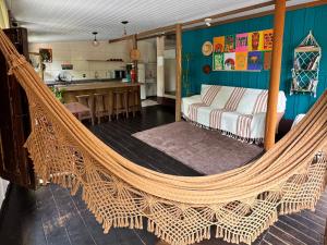 a hammock in a room with a kitchen at Hostel Antônio Pescador - Centro da Guarda do Embaú in Guarda do Embaú
