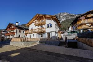 a large white house with a wooden roof at Chalet Boscopiano in Valdidentro