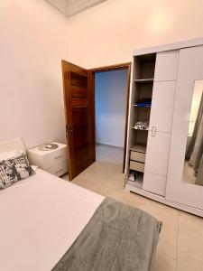 a bedroom with a bed and a closet and a mirror at Charmant Studio in Dakar