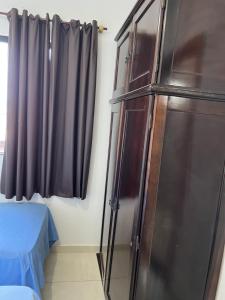 a refrigerator in a room with a bed and a window at Apto Ninho Sereno em ilheus in Ilhéus