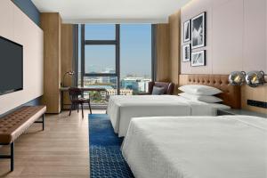 a hotel room with two beds and a large window at Four Points by Sheraton Hefei High-Tech Zone in Hefei