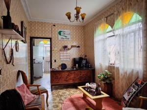 a living room with a table and stained glass windows at Vila Mariah Hostel in Belo Horizonte