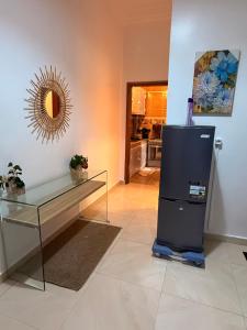 a living room with a glass table and a refrigerator at Charmant Studio in Dakar