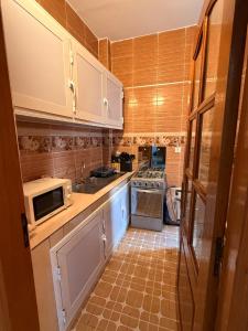 a kitchen with white cabinets and a tile floor at Charmant Studio in Dakar