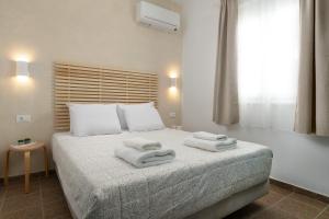 a bedroom with a bed with towels on it at Oniro Beach House in Archangelos