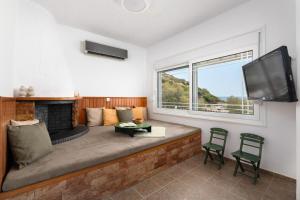 a living room with a couch and a fireplace at Oniro Beach House in Archangelos