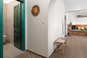 a room with a green door and a stool at Oniro Beach House in Archangelos +12 photos
