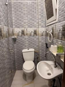a small bathroom with a toilet and a sink at Charmant Studio in Dakar