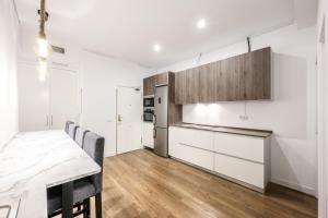 a kitchen with white cabinets and a table with chairs at Agora Boutique Coliving Madrid in Madrid +72 photos
