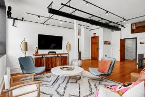 a living room with a table and chairs and a tv at Luxe 220 Suite 1 in Wilmington