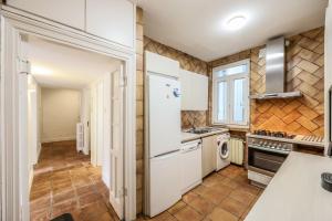 a kitchen with a white refrigerator and a stove at Agora Boutique Coliving Madrid in Madrid