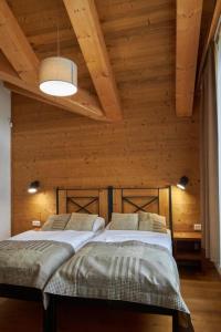 two beds in a room with wooden walls at Chalets Jasná Centrum APT KROWKA - Free Jacuzzi & Sauna and Chopok view in Belá +23 photos