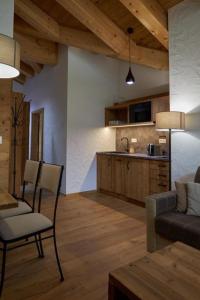 a kitchen and living room with a couch and a table at Chalets Jasná Centrum APT KROWKA - Free Jacuzzi & Sauna and Chopok view in Belá