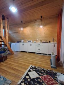 a large kitchen with white cabinets and a wooden ceiling at Cottage Mida in Mestia