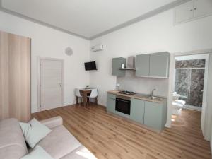 a living room with a couch and a kitchen at Casa Dante 4 in Pavia
