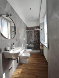 a bathroom with two toilets and a sink and a mirror at Casa Dante 4 in Pavia