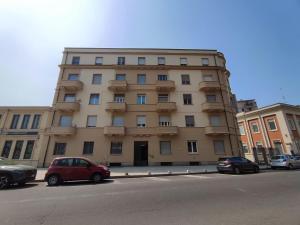 a tall building with cars parked in front of it at Casa Dante 4 in Pavia
