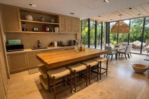 a kitchen with a large wooden table and chairs at Luxury Villa in Corasol 4BR Private Pool in Playa del Carmen