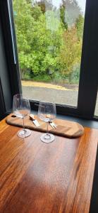 two wine glasses sitting on a table next to a window at Frogs Hollow in Greytown +21 photos