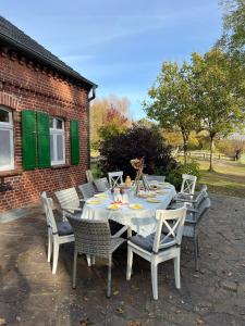 a table and chairs sitting on a patio at Elbferienhaus Lenzerwische - gemeinsames Urlauben an der Elbe mit privaten Badesee - alles inklusive in Lenzerwische