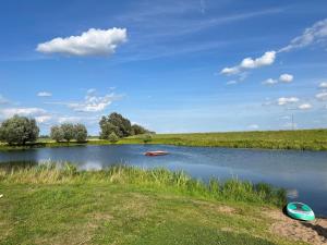 a lake with two boats in the water at Elbferienhaus Lenzerwische - gemeinsames Urlauben an der Elbe mit privaten Badesee - alles inklusive in Lenzerwische