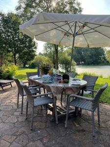 a table with an umbrella on a patio at Elbferienhaus Lenzerwische - gemeinsames Urlauben an der Elbe mit privaten Badesee - alles inklusive in Lenzerwische