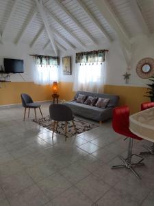 a living room with a couch and chairs at Haut de villa " JODI " in Sainte-Rose