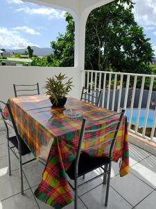 a table with a colorful table cloth on a patio at Haut de villa " JODI " in Sainte-Rose