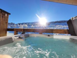 a jacuzzi tub with a view of the snow at Chalets Jasná Centrum APT KROWKA - Free Jacuzzi & Sauna and Chopok view in Belá