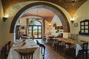 a dining room with tables and chairs and a window at Terre di Nano in Monticchiello