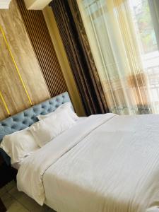 a bedroom with a large bed with a window at Kigali Sky Light Homes in Kigali