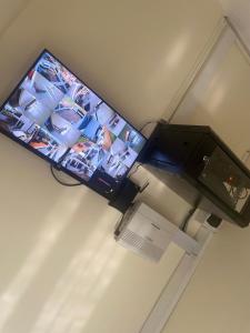a tv hanging on a wall next to a printer at Kigali Sky Light Homes in Kigali
