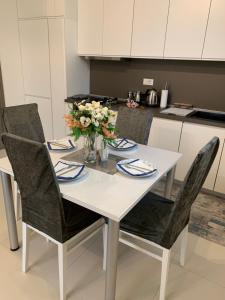 a white table with chairs and a vase of flowers at Aura in Kumanovo