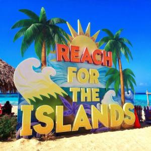 a sign on the beach with the words reach for the islands at Reach For The Islands in Corn Islands