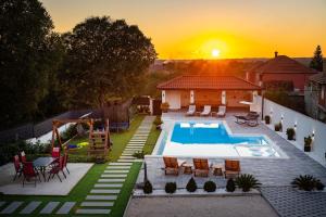a backyard with a swimming pool and a sunset at My Dalmatia - Apartment M&N with shared pool in Galovac