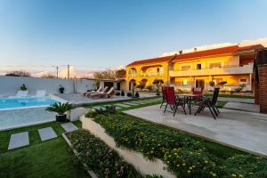 a house with a patio with a table and chairs at My Dalmatia - Apartment M&N with shared pool in Galovac +58 photos