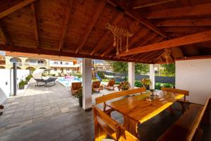 an outdoor patio with a wooden table and chairs at My Dalmatia - Apartment M&N with shared pool in Galovac