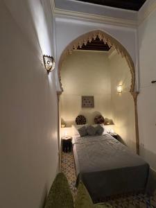 a bedroom with a bed in a room with an arch at Riad Dar Chaafa 17 in Salé