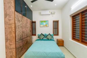 a bedroom with a bed with blue pillows at Greenview Royal Stay Near Amrita Hospital Edappally in Cochin