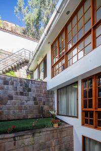 an external view of a house with a brick wall at Mamasara Cusco in Cusco