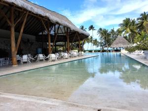 a large swimming pool with chairs and a building at Beachfront Portillo Residence in Las Terrenas