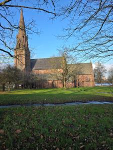 a large brick church with a tower and a steeple at Magic Stays! in Halton
