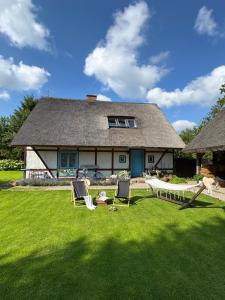 a house with a yard with chairs and a table at Chata na Zielonym Wzgórzu in Garcz