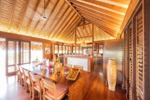 a dining room with a large wooden table and chairs at Villa Heremoana in Maharepa
