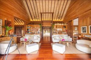 a living room with white furniture and wooden walls at Villa Heremoana in Maharepa +29 photos