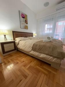 a bedroom with a large bed and a wooden floor at Dolce Casa E K in Strumica