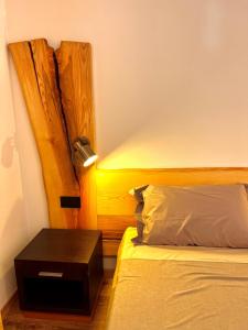 a bedroom with a bed with a nightstand next to it at Nos Sweet Home in Dimaro