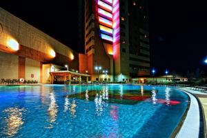a large swimming pool in front of a building at night at Downstream Casino Resort in Loma Linda
