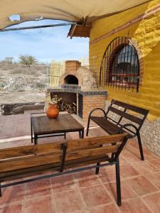 a patio with two benches and a fireplace at Eco ITZKA Bernal Country House in Bernal