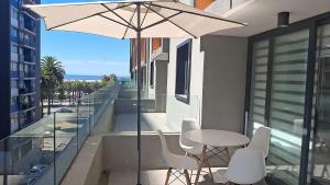 a balcony with a table and chairs and an umbrella at Vistas de Valparaíso 617 in Valparaíso